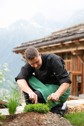 A chef picking local herbs outside of a house in the valley.